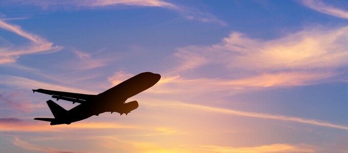 An airplane flying during sunset