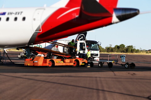 A person loading a cargo to a plane